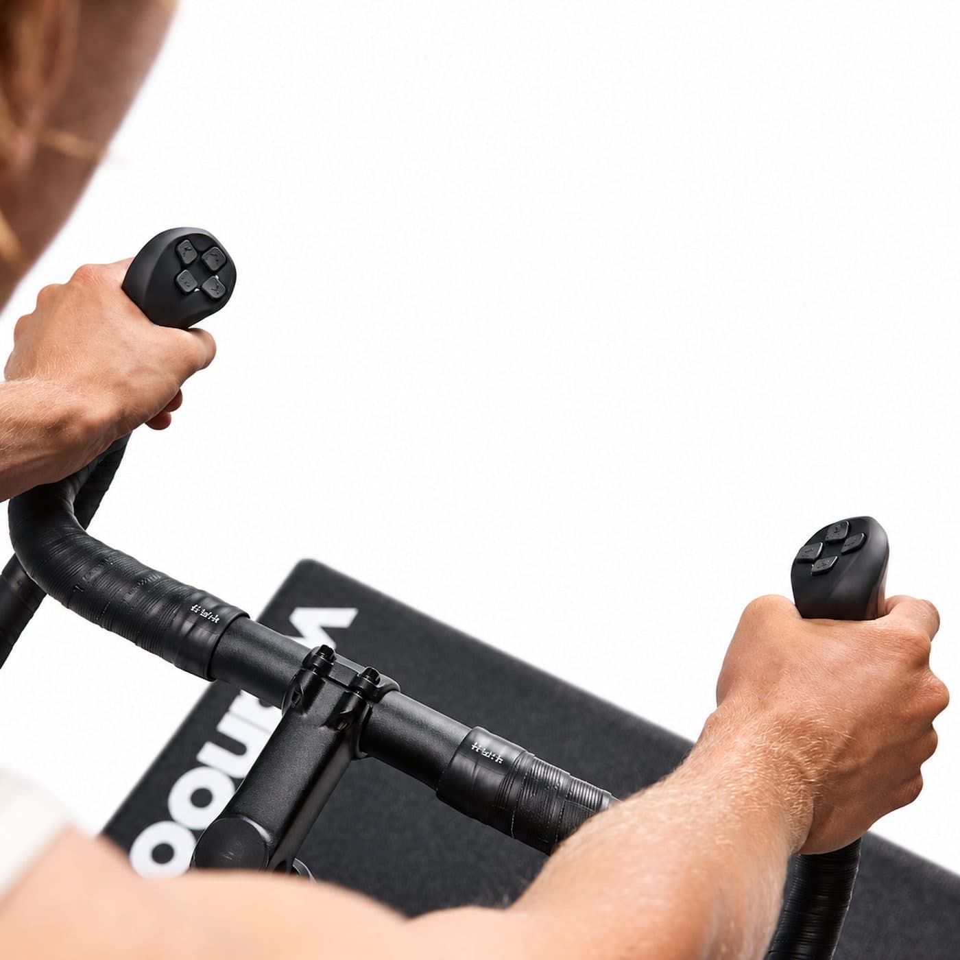 Руль Wahoo KICKR BIKE PRO с кнопками управления Zwift в руках велосипедиста