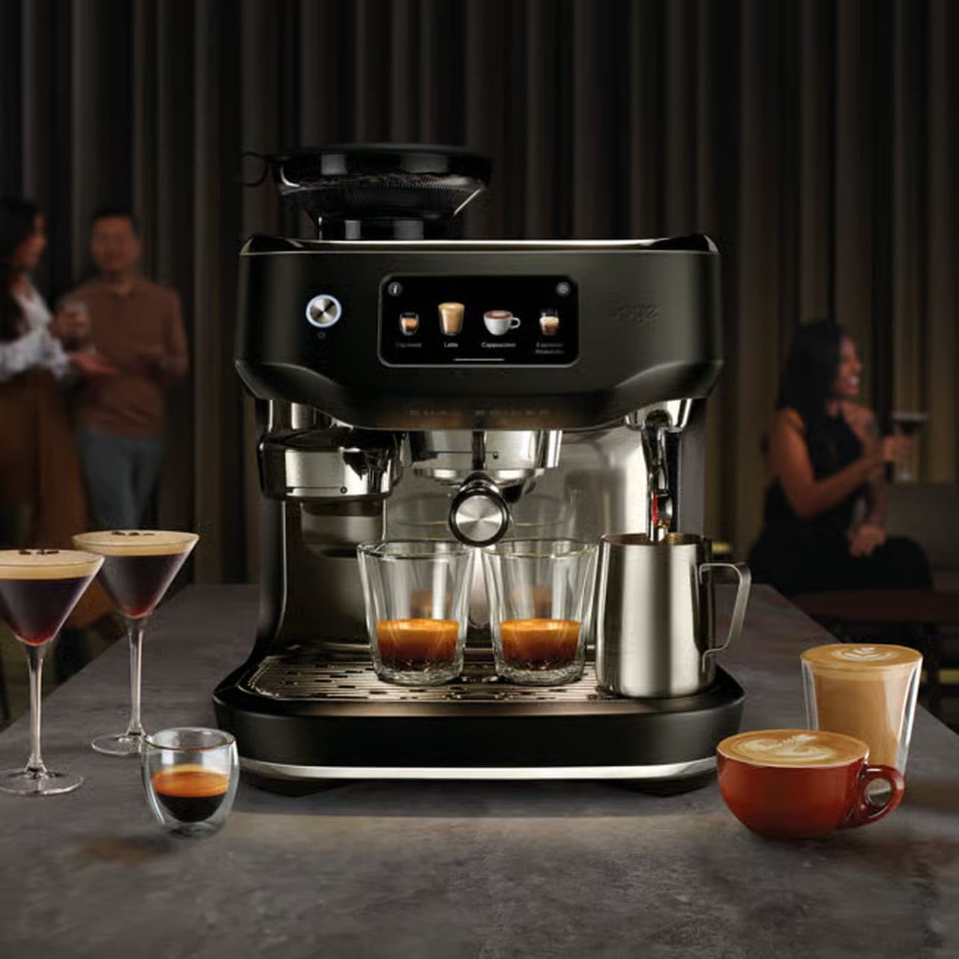Чёрная Sage Oracle Dual Boiler в интерьере, цветная фотография с людьми на заднем плане
